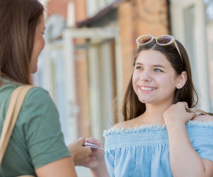 Teen girl taking a debit card from her mother.
