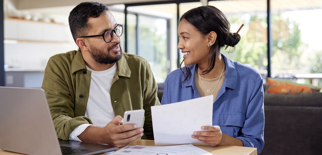 A smiling man and woman discussing their finances