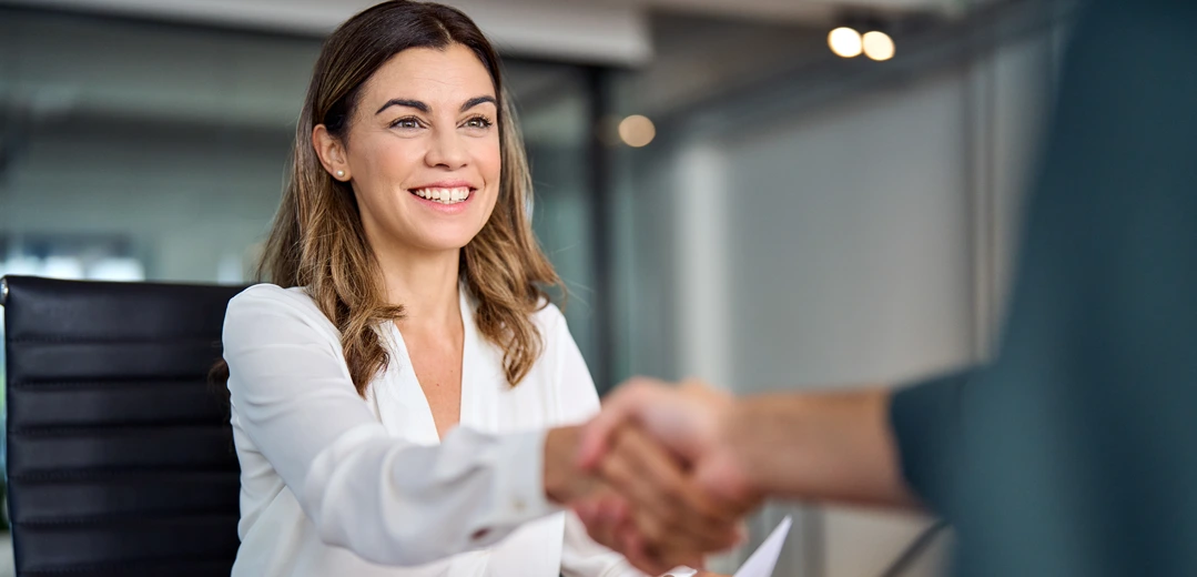 A happy woman shaking hands with a member service representative